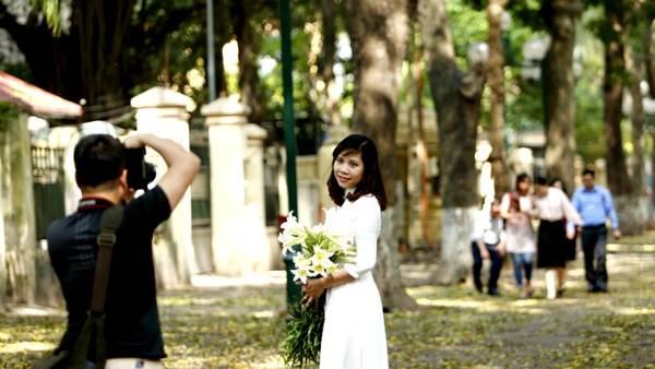 Sẽ thật thiếu xót nếu không miêu tả vẻ đẹp Hà Nội lại không nhắc đến những thiếu nữ trong tà áo dài trắng, cầm bó hoa loa kèn thướt tha bước đi giữa những con đường ngập lá vàng.