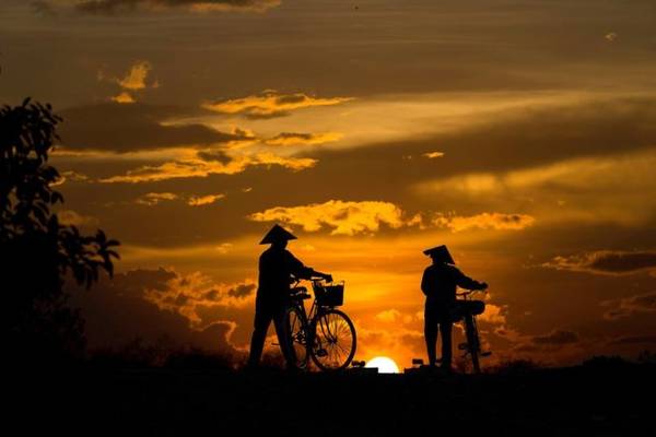 Người nông dân gánh lúa trên con đường quê Hà Tây
