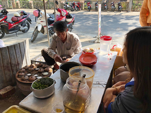 Đầu bếp 60 tuổi thoăn thoắt làm bánh căn Đà Lạt phục vụ khách.