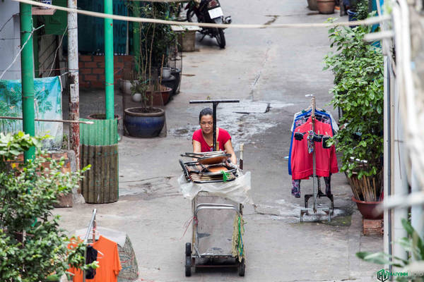 Một chị chuẩn bị dọn hàng cho ngày buôn bán mới trong hẻm Hào Sĩ Phường
