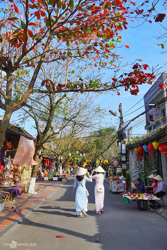 Hai phụ nữ trong tà áo dài khám phá nhịp sống Hội An trên đường Nguyễn Thị Minh Khai. Hội An có những con đường ngắn và hẹp, chạy dọc và ngang theo hình bàn cờ, cứ đi hết hẻm này là gặp hẻm khác.