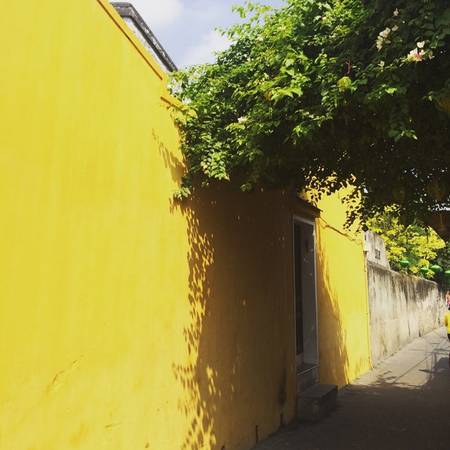 Nhớ về Hội An là nhớ những mảng tường vàng từ phố này qua phố khác. Khi đặt cạnh đó một khóm hoa giấy, tường là cái nền tuyệt vời của một bức tranh. Khi đặt lên đó một khung cửa gỗ nâu, ta biết ở đằng sau đó, đời sống êm đềm đã nối nhau hàng thế kỷ.