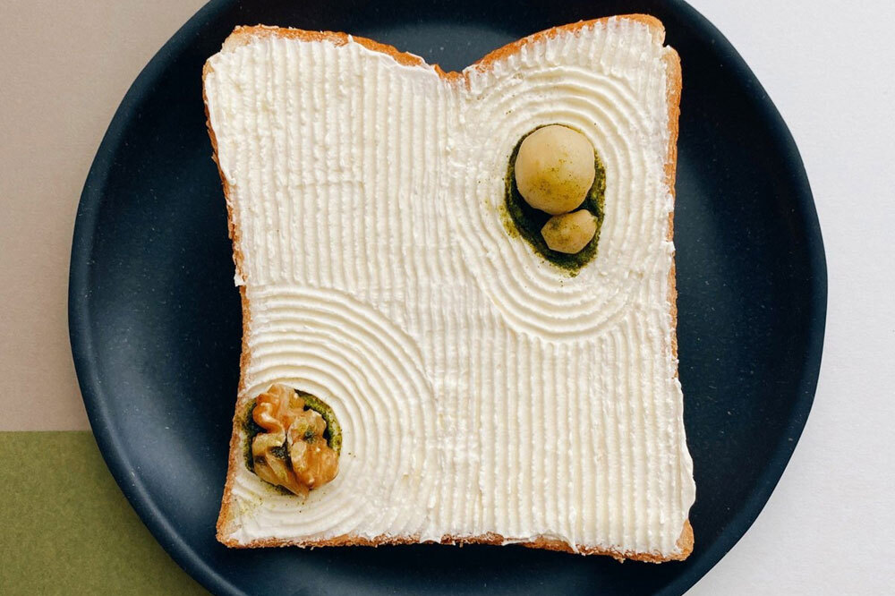 Lát bánh mì lấy cảm hứng từ vườn đá - một nét văn hóa đặc trưng của Nhật Bản, làm từ kem chua, các loại hạt và matcha.   “Tôi chọn chủ đề vào đêm hôm trước, nghĩ về những nguyên liệu mà tôi thích ăn vào sáng hôm sau. Sau đó, tôi đến cửa hàng tạp hóa, mua thêm các nguyên liệu mới và về nhà để sáng tạo. Khoảng 60% phần chuẩn bị cho món ăn được hoàn thành vào đêm hôm trước. Tôi thức dậy vào buổi sáng, hoàn thành tác phẩm sau đó chụp ảnh và ăn”, nghệ sĩ cho biết. Ảnh: Manami Sasaki.