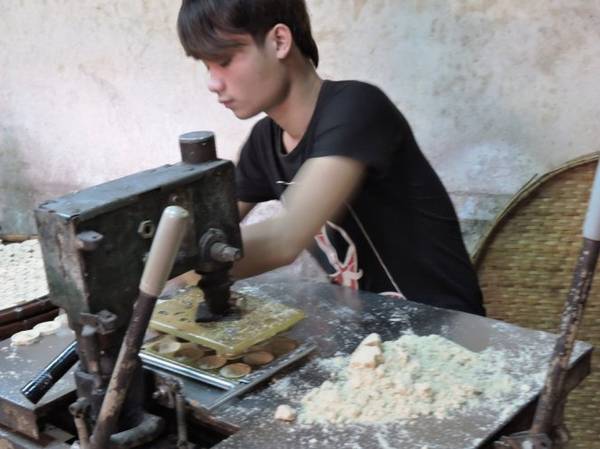Bột được cho vào khuôn để in bánh đậu xanh Hội An. Ảnh: T.Ly