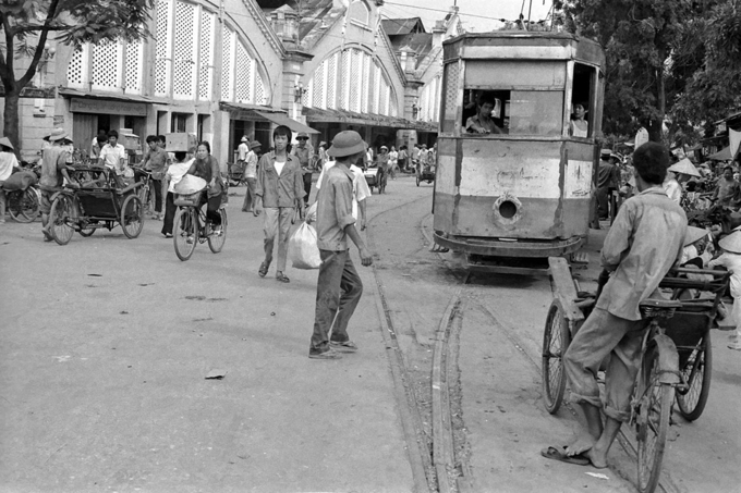 Hình trên được chụp năm 1989.  Vào khoảng năm 1990, chợ được xây dựng lại, phá bỏ hai dãy hai bên, ba dãy giữa xây lên ba tầng. Hai tấm cửa hai bên cũng bị dỡ, nhưng vẫn còn giữ hai cột ngoài cùng. Đến năm 1994, chợ Đồng Xuân đã bị hỏa hoạn, lửa thiêu trụi gần như toàn bộ gian hàng trong chợ. Đây là vụ cháy chợ lớn nhất tại Hà Nội cho đến nay. Ảnh: Flickr.