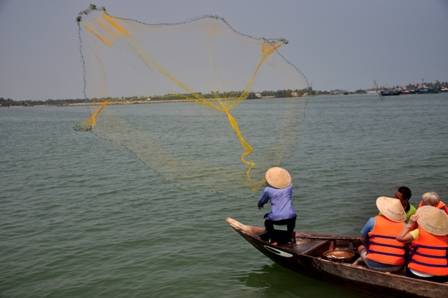 Du khách quan sát cách quăng chài trong tour ngư dân Hội An