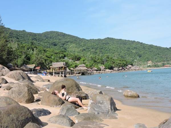 Du khách nằm phơi nắng trên đá tại bãi Rạng Đà Nẵng