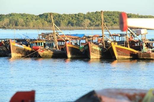 Những con thuyền gỗ sờn cũ vì năm tháng nằm lặng im bên nhau ngắm hoàng hôn dần buông xuống trên xã đảo thân thương