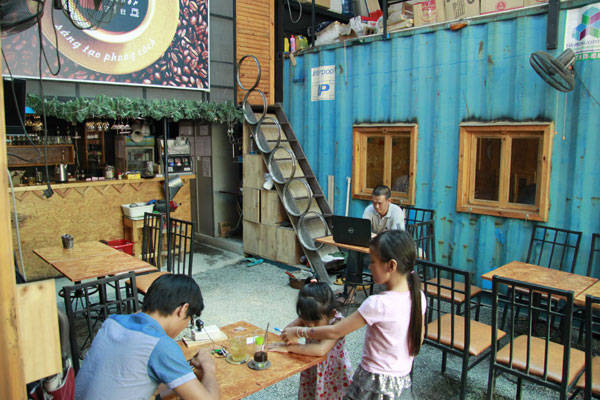 Bàn ghế từ bánh xe ô tô cũ và thùng phi tại quán cà phê container
