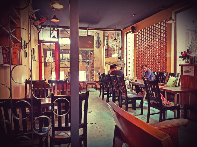 Nội thất quán tinh giản, kết hợp hài hòa giữa lớp sơn màu vàng phủ tường và bức tường gạch, khung cửa sắt. Các bộ bàn ghế có hai màu cơ bản: cam và đen. Tất cả được phủ một lớp vecni sáng bóng. Anh Văn kể có những chú, bác lớn tuổi nhà gần rất thích hẹn bạn đến đây bàn công việc hay chơi cờ tướng.