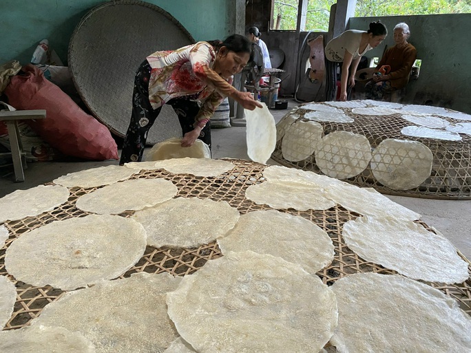 Hong khô bánh tráng trên than. Ảnh: Báo Người Lao động.