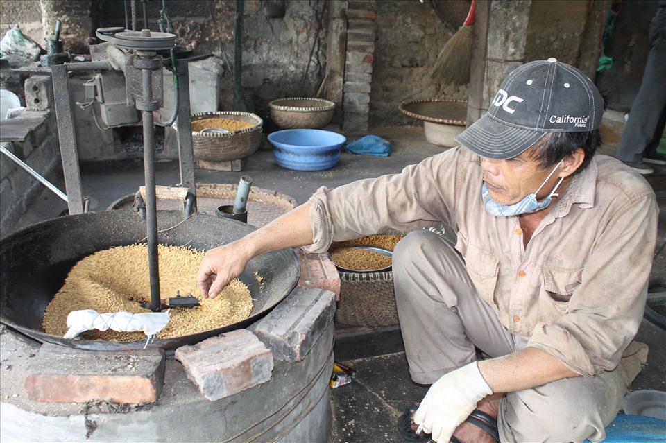Điều chỉnh lửa cho mẻ thóc tại làng cốm Nông Xá
