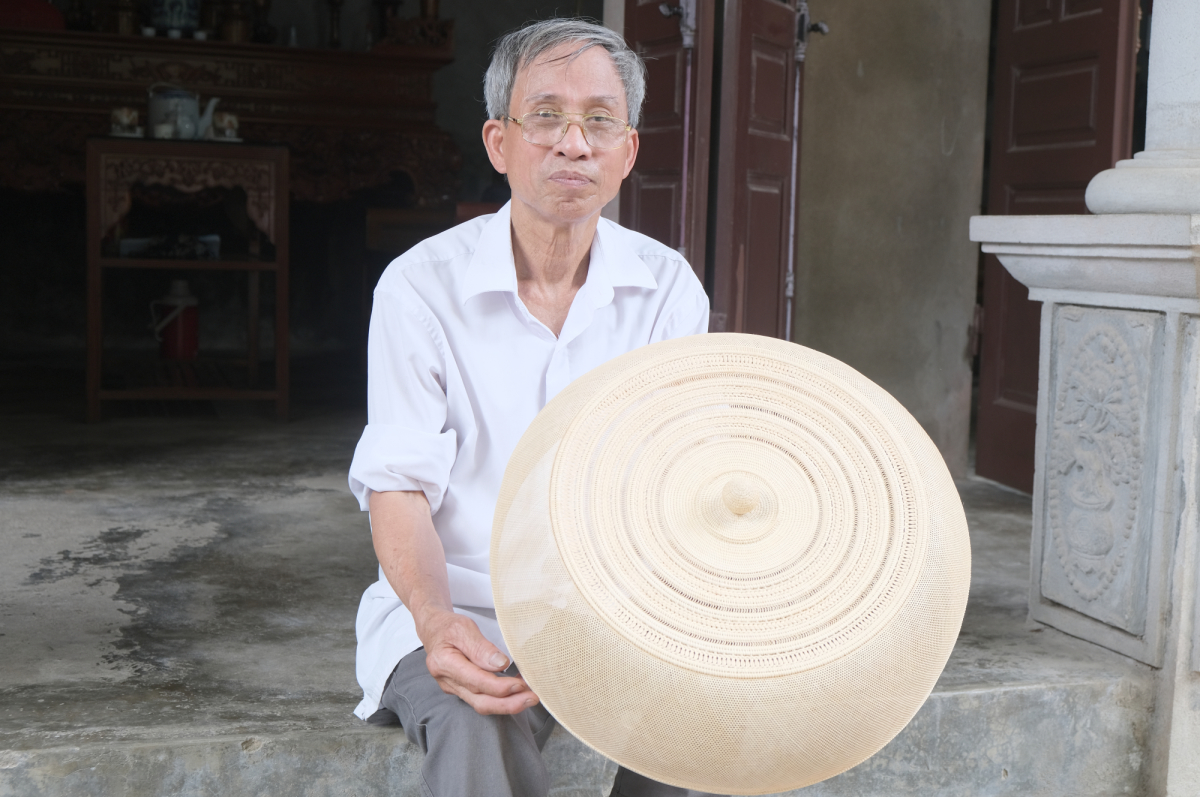 Ông Khá bên chiếc lồng bàn. Ảnh: Vnexpress.