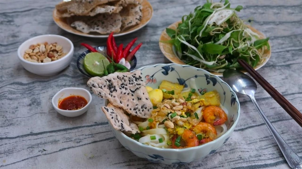 Mì Quảng hoàn thiện với rau thơm và đậu phụng