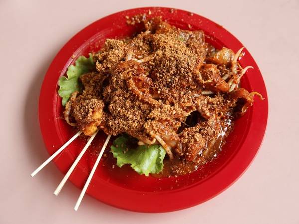 Rojak - salad rau quả món ăn đường phố Singapore. Món ăn làm từ dứa, dưa chuột, bột chiên với sốt cá, thêm chút lạc xay rắc lên trên, hòa trộn vị ngọt cay.