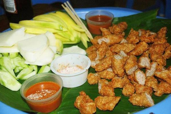 Ngõ Tạm Thương nhỏ hẹp nằm khuất trên phố Hàng Bông sầm uất, chỉ dài khoảng 10 m nhưng có đến 6, 7 hàng cùng bán nem chua rán - món ăn mang lại thương hiệu cho con ngõ này. Ở đây có phong cách “ẩm thực hè phố” với hình ảnh quen thuộc là thực khách ngồi trên những chiếc ghế nhựa. Nem chua để trong những khay lót lá chuối, đặt lên một chiếc ghế khác làm bàn. Khoai tây chiên, củ đậu cũng là những món ăn kèm được yêu thích. Giá phần nem 10 cái là 50.000 đồng. Ảnh: Từ Văn Công.