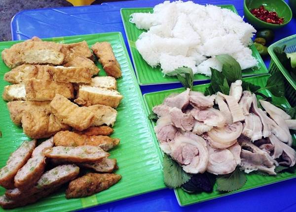 Với chiều dài chưa tới 100 m, ngõ Phất Lộc luôn tấp nập, nhất là buổi trưa với nhiều món ngon, trong đó được yêu thích nhất là bún đậu mắm tôm. Bước chân vào ngõ nhỏ này bạn sẽ thấy các hàng bún đậu trải dài hai bên đường. Mỗi suất bún đậu thông thường gồm bún lá và đậu chiên, chấm mắm tôm, ăn kèm rau sống có giá khoảng 20.000 đồng. Thực khách thường gọi suất bún đậu thập cẩm có thêm nộm sứa, đậu nướng, chả cốm, thịt luộc mắm tép, ốc om chuối đậu, lòng dồi.... giá khoảng 100.000 đồng cho 2 người. Ảnh: Leo Phan.