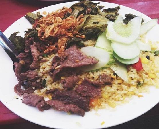 Ngõ Tràng Tiền hẹp, nằm giữa phố Nguyễn Khắc Cần và Phan Chu Trinh, tấp nập thực khách buổi trưa. Ở đây ngoài món bún đậu lòng rán, cơm rang dưa bò cũng được nhiều người yêu thích. Hạt cơm vàng ươm, đủ độ dẻo, dưa được xào vừa chín tới, lúc ăn vẫn giữ được cái giòn và chua chua đặc trưng của dưa muối, thịt bò chín vừa tới, đậm đà tạo nên sức hút của món này. Giá một phần từ 30.000 đồng. Ảnh: Giang.