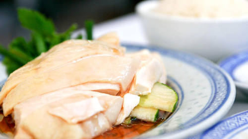 Khi người Hải Nam di cư đến Singapore vào khoảng giữa thế kỷ 19, họ chỉ làm phục vụ cho thực dân Anh hoặc giúp việc tại các quán ăn. Người Hải Nam thường phục vụ chủ nhà món cơm gà. Họ nghĩ món gà luộc đơn giản sẽ hài lòng mọi khẩu vị khác nhau. Câu chuyện cơm gà bắt đầu thay đổi khi người Nhật sang chiếm đóng trong thế chiến thứ 2. Người Anh buộc phải đi khỏi Singapore và người Hải Nam mất việc làm. Khi đó nhà hàng cơm gà đầu tiên ra đời giúp họ kiếm sống.