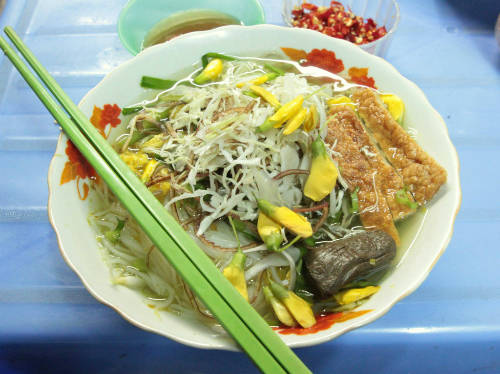 Ngoài những miếng cá lóc đặc trưng trong tô bún cá thì còn có thêm những thớ chả cá chiên thơm lừng chấm nước mắm ớt rất ngon, và bông điên điển sản vật đặc trưng của miền Tây.