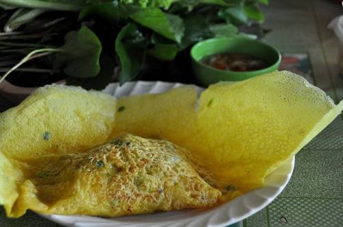 Bánh xèo được thưởng thức tùy theo sở thích, cho từng miếng vào chén rồi chan nước mắm, hoặc cuốn với rau thơm. Ảnh: Ngoisao.