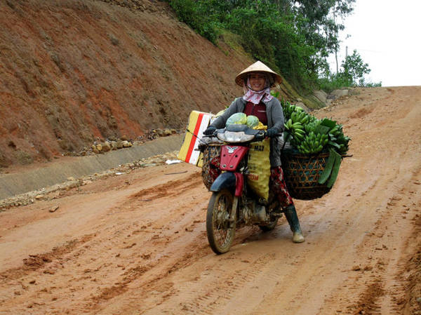Một phụ nữ dùng xe máy chuyển lâm sản về xuôi (bao chứa dâu da đặt phía trước) - Ảnh: MINH KỲ