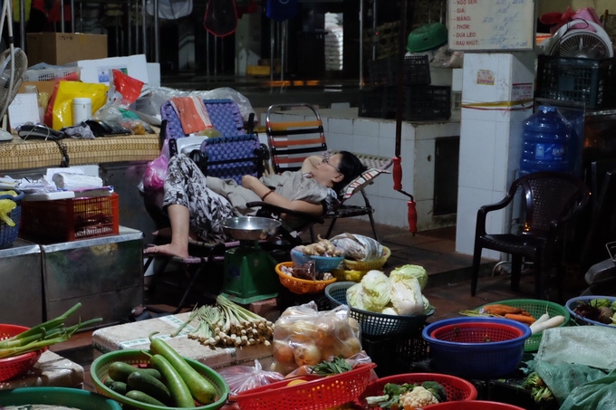 Một chủ hàng tranh thủ chợp mắt trong chợ.