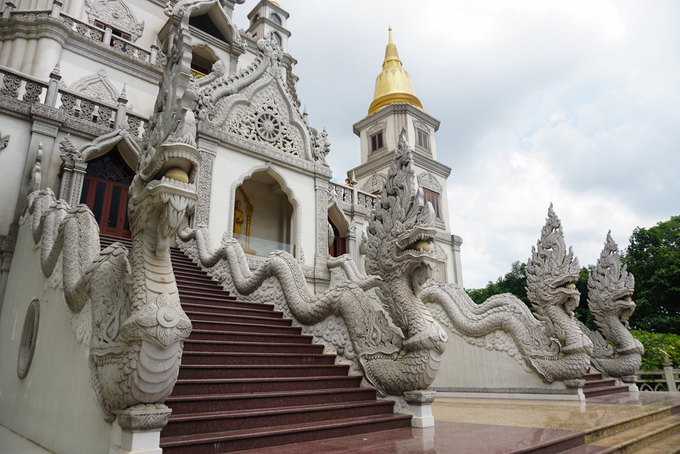 Cạnh hồ nước là lối lên bảo tháp, du khách phải bỏ dép ở dưới sân nếu muốn lên các tầng lầu. Xung quanh lối lên là linh vật rồng ngậm ngọc uốn lượn cùng mây.  Kiến trúc của chùa mang nét Phật Giáo Nam Tông đặc trưng trong vùng Đông Nam Á, với các họa tiết trang trí như rồng uốn lượn tạo thành mái vòm, hoa văn nổi, phù điêu, bánh xe chuyển pháp luân,...