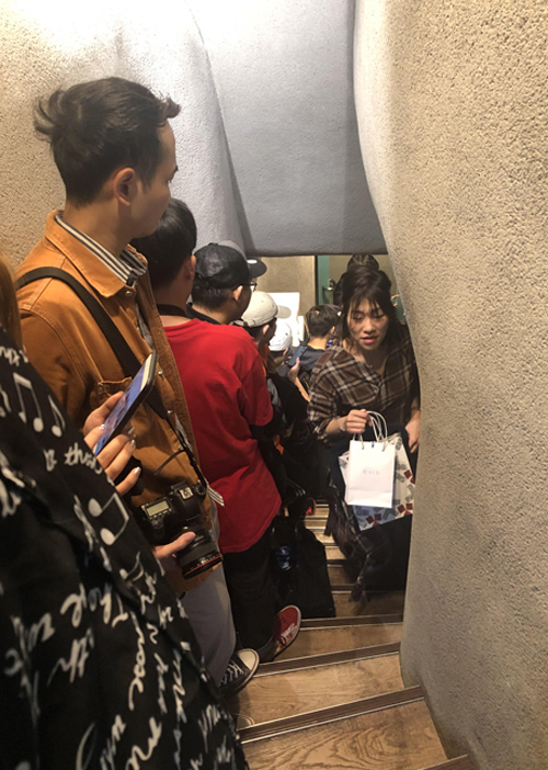 Hành khách chờ tới lượt vào quán Phở Thìn Tokyo. Lối xuống hầm chật hẹp nên khách phải nép người sang một bên.