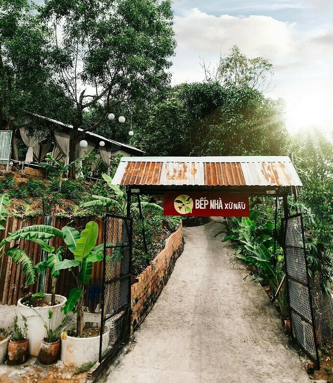 Bếp Nhà Xứ Nẫu nằm ở số 68 Nam Cao, TP Quy Nhơn, tỉnh Bình Định. Nhà hàng tái hiện lại khung cảnh làng quê với ngõ quanh co, hàng cây rợp bóng, có giàn bầu, gốc chuối... quen thuộc, giúp mang đến không gian yên bình cho thực khách.