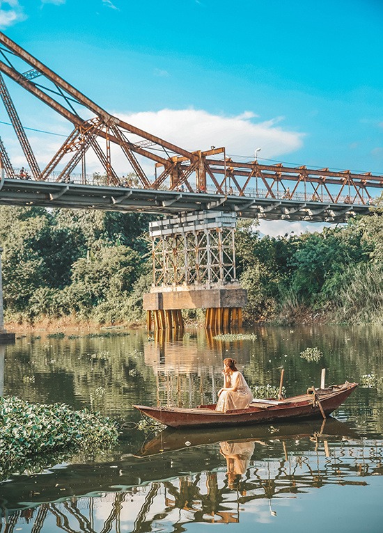 “Hay ngắm cầu Long Biên từ một chiếc thuyền lững lờ trôi trên sông cũng là một trải nghiệm nên thử”, Trang chia sẻ. Từ chân cầu Long Biên, cô có thể ngắm cảnh sắc bình yên của dòng sông Hồng. Hướng mắt lên cao hơn là những dòng người xe tấp nập qua lại trên cầu.