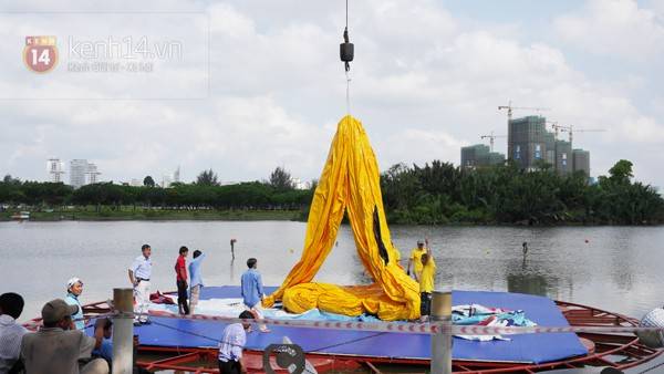 Di chuyển chú vịt vàng khổng lồ ra giữa hồ Bán Nguyệt bằng cần móc lớn.
