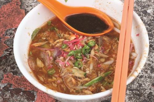 Assam laksa Bạn có thể tìm thấy món này trong quầy bán ở Weld Quay - khu phố khá nhộn nhịp ở George Town, Penang. Đây là món mì gạo nấu với nước súp cá và me. Trong tô mì có rắc thêm ít hoa gừng, ớt và dưa chuột xắt nhỏ. Tiệm có cả ghế ngồi, khách mua mang đi chỉ cần tạt xe vào yêu cầu là được.