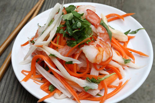 Gỏi ngó sen Ngó sen sau khi sơ chế trở nên trắng và giòn, trộn cùng tôm thịt tạo nên món gỏi hấp dẫn. Nước trộn có đủ vị từ dấm, chanh, ớt, tỏi tạo đủ vị chua, cay, mặn, ngọt. Tôm tươi bóc vỏ và thịt luộc phải ngon thì món gỏi mới trọn vị. Món này ít bán ở vỉa hè, chủ yếu bán trong các quán ăn gia đình, nhà hàng, với giá từ 60.000 đồng một đĩa. Ảnh: Cún Khang.