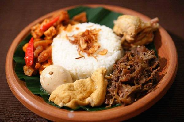 Gudeg là món ngon Indonesia đặc sản Yogyakarta, mít hầm với nước dừa và đường cọ, ăn cùng cơm, trứng luộc, gà và da bò chiên giòn. Ảnh: Wonderfuljogja.