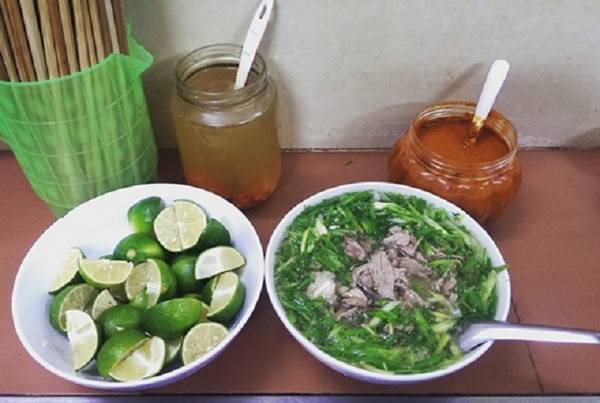 Phở Thìn: Suốt ba thập kỷ, quán ăn trên phố Lò Đúc chỉ phục vụ phở bò tái lăn nhưng luôn đông khách. Thịt bò của món phở ở đây không được nhúng tái mà mang xào nhanh trên chảo lớn với đủ gia vị, hành tỏi, gừng tươi rồi mới cho vào bát. Bởi vậy mà không chỉ thịt thơm, đậm đà, nước dùng còn khá ngậy với lớp mỡ nóng già bên trên. Bạn phải xếp hàng đợi ở cửa quán để gọi số lượng và trả tiền trước khi vào bàn. Quán chật chội, phục vụ không tận tình, giá một tô phở là 50.000 đồng nhưng vẫn nườm nượp khách ta và Tây. Ảnh: Phiêu Linh.