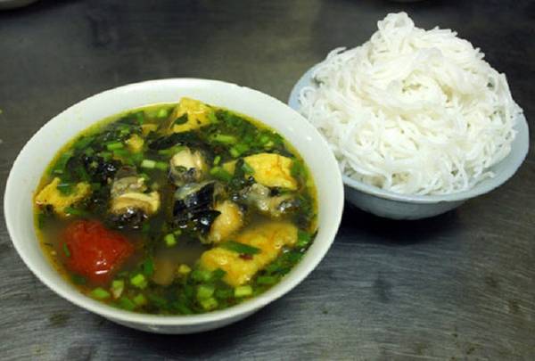 Bún ốc: Cuối ngõ chợ có quán bún ốc nhỏ, ít chỗ ngồi nhưng tấp nập khách ra vào, đặc biệt cao điểm vào buổi trưa. Bạn sẽ bị hấp dẫn bởi ốc nhồi béo và giòn, nước dùng chua chua, thơm nhẹ nhàng vị giấm bỗng. Ngoài bún chan, quán còn phục vụ bún chấm dành cho những thực khách muốn đổi kiểu ăn. Ở đây, bún rối được để riêng, khi ăn mới cho vào bát nước dùng nóng hổi với đầy đủ ốc, chuối, đậu. Mỗi bát bún chan có giá 30.000 đồng, còn bún chấm 35.000 đồng một bát. Quán mở cửa từ 10h đến 16h hàng ngày. Ảnh: Ngoisao.