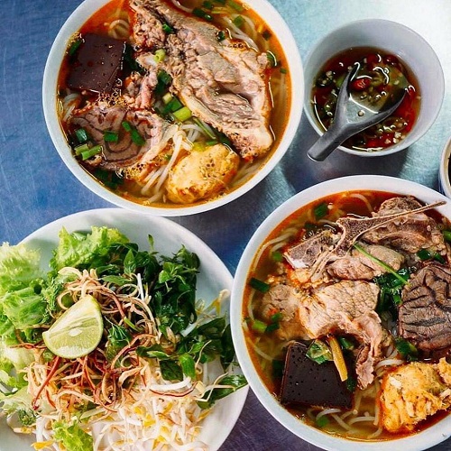 Nước dùng bún bò Huế có vị ngọt thanh và màu đỏ sa tế tại quán ăn Huế Hội An