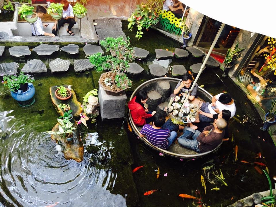 Oasis Coffee  Không gian ngoài trời có lẽ là khu hút khách nhất của quán cà phê trên đường Lê Lợi, quận Gò Vấp. Cây cối được bố trí khắp nơi tạo cảm giác thoải mái, gần gũi thiên nhiên.  Phần không gian này còn được thiết kế thêm bàn ngồi dưới lòng hồ cá. Khách ngồi uống cà phê sẽ có cảm giác như đang "bơi cùng bầy cá". Ảnh: Đỗ Hoàn Tuấn.