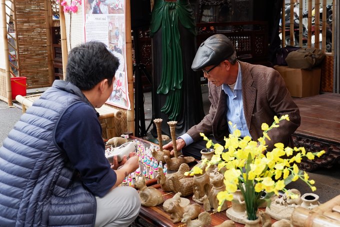 Nghệ nhân giới thiệu nghề nặn phỗng tại phố bích họa Phùng Hưng.