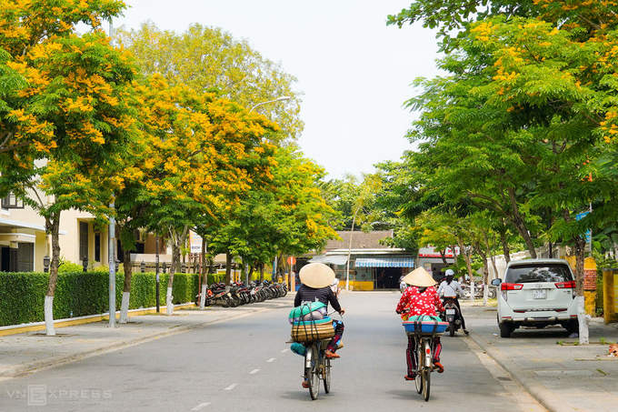 Hai phụ nữ đạp xe bán hàng trên đường Phan Chu Trinh, Hội An. Covid-19 khiến Hội An vắng khách tham quan, đường phố vì thế tĩnh lặng hơn.