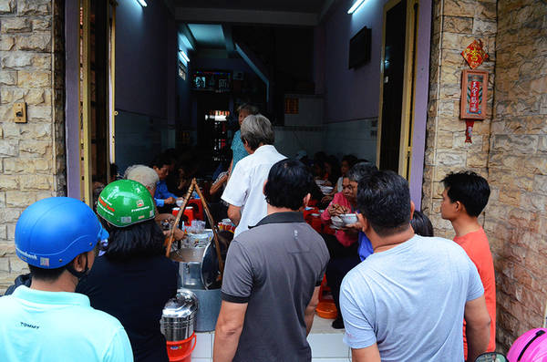 Nơi này được khách gọi là quán, cũng có người gọi là hàng rong. Quán tuy bán trong gian nhà khang trang, nhưng khu vực bếp chỉ đơn giản là một gánh hàng bày các vật dụng, nguyên liệu để nấu món ăn. Quán không có bàn, thực khách ngồi trên ghế nhựa và dùng nó làm bàn. Ảnh: Phong Vinh
