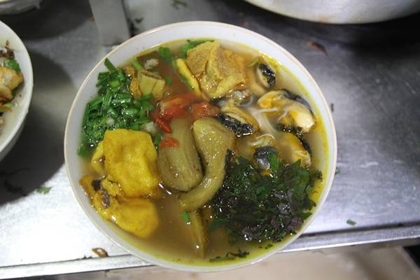 Miến chan thập cẩm thơm vị của cua, bùi và ngậy với cá rán, giòn giòn với giò tài ăn kèm với trứng cút, đậu rán chan nước dùng nóng hổi.