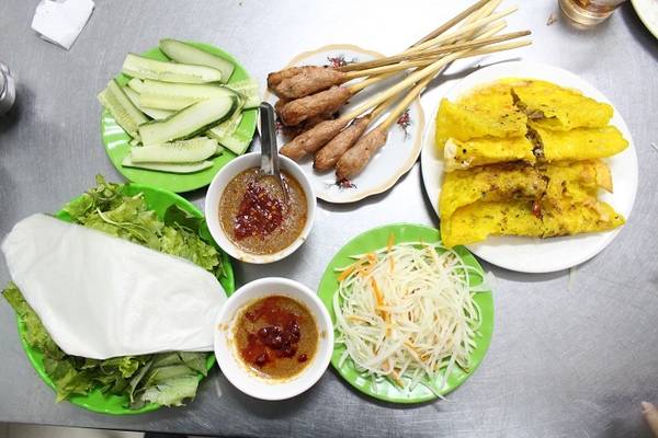 Chủ quán là bà Trương Thị Lai, 77 tuổi, mở quán này đã hơn 30 năm. Bà chia sẻ, nguyên liệu làm bánh phải dùng loại gạo xiệc ở Quảng Nam pha thêm ít bột nghệ để tạo màu và ngâm trong bốn giờ để gạo mềm, mịn, khi chiên trên bếp miếng bánh sẽ có vị dẻo và giòn.