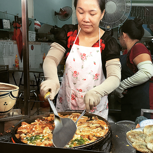 Nằm ngay mặt đường Võ Văn Tần, quận 3, quán bột chiên này mở bán cách đây 30 năm. Theo lời chủ quán, ngày trước nơi này ít người biết đến. "Người này đến ăn rồi truyền tai cho người khác nên quán mới đông như bây giờ", chủ quán vừa chiên bánh vừa nói.