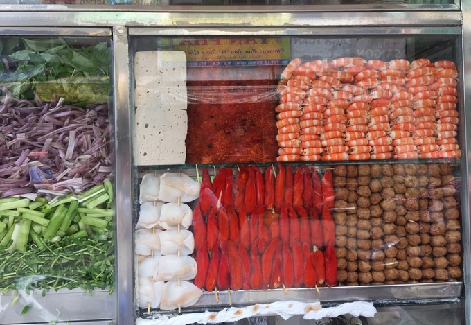 Đồ ăn kèm màu sắc hấp dẫn như ớt nhồi chả cá, tôm luộc bóc vỏ, mực, chả lụa, thịt heo quay... xếp ngay ngắn trong tủ kính.