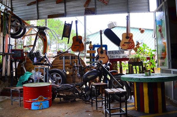 Một góc bên ngoài của quán được lấp đầy bởi chiếc mô tô lắp dở cùng những chiếc đàn ghi ta. Đây là những đồ vật vốn quen thuộc đối với các phượt thủ.