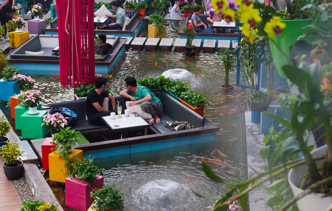 Gần tháng nay, một quán cà phê độc đáo xuất hiện trên đường Khổng Tử (quận Thủ Đức, TP HCM) thu hút nhiều khách tham quan. Theo đó, không gian chính của quán là một hồ nước với những chiếc bàn đặt giữa lòng hồ.