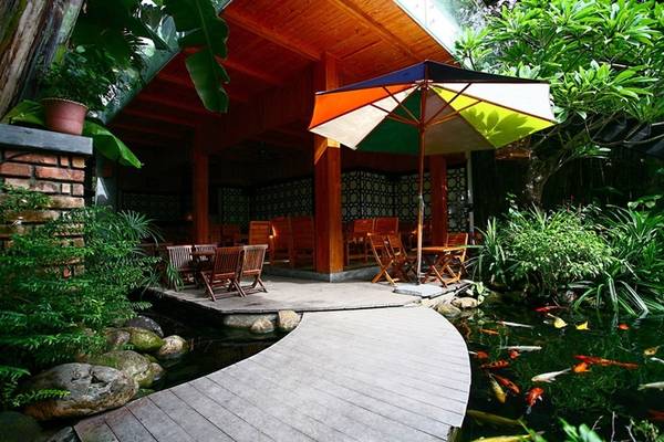 Quán có nhiều không gian. Có chỗ trong nhà, ngoài sân, tầng trệt hay tầng lầu. Một chiếc cầu nhỏ bắc qua hồ nước vào phía trong, nơi tầng trệt mở thoáng của ngôi nhà. Đây là một không gian chỉn chu, lịch sự với chất liệu chủ đạo là gỗ.