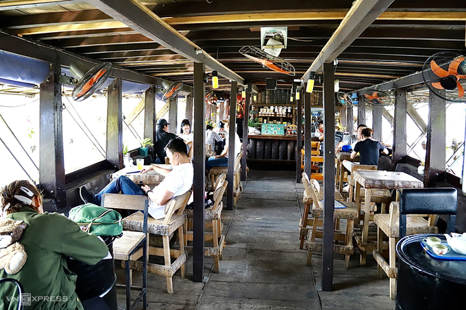 Bên trong quán cà phê lênh đênh sử dụng nội thất gỗ. Khách gọi nước tại quầy và được phục vụ tận chỗ ngồi. Mô hình cà phê này đã mở gần 10 năm.
